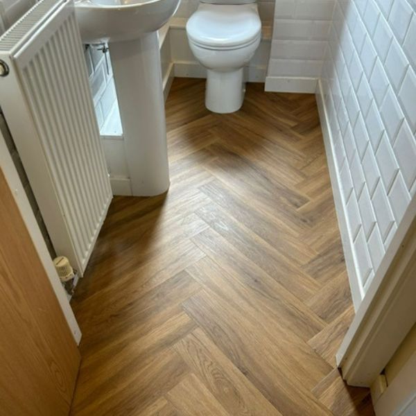 Studio Designs LVT in California Oak, Herringbone style installed in downstairs toilet in Northamptonshire