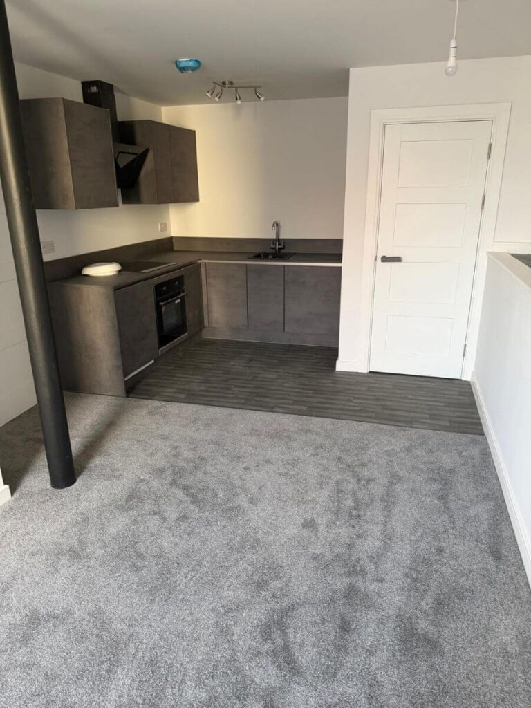 Grey vinyl tile flooring and grey carpets installed in the open plan living area / kitchen at the flats at Allinson House in Northampton.