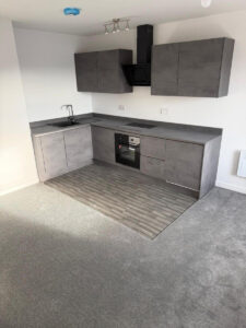 Grey vinyl tile flooring and grey carpets installed in the open plan living area / kitchen at the flats at Allinson House in Northampton.
