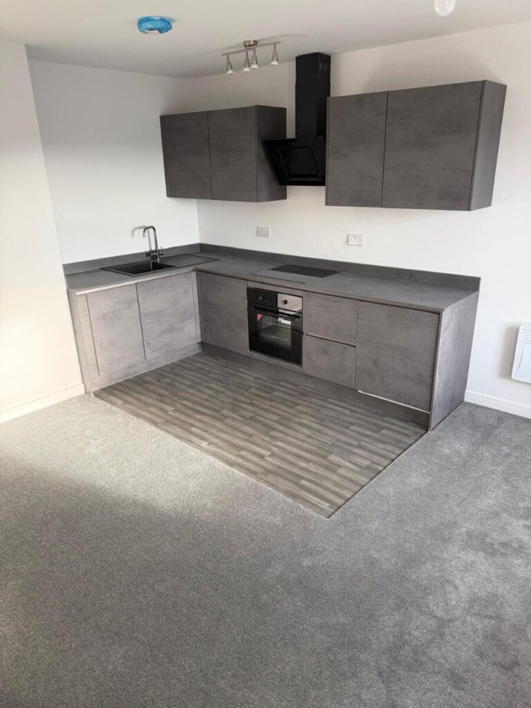 Grey vinyl tile flooring and grey carpets installed in the open plan living area / kitchen at the flats at Allinson House in Northampton.