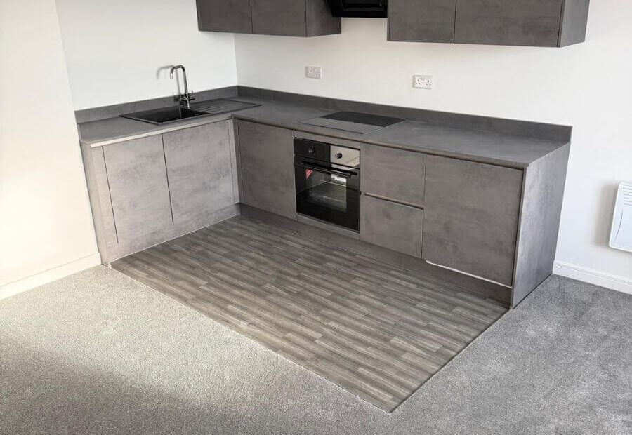 Grey vinyl tile flooring and grey carpets installed in the open plan living area / kitchen at the flats at Allinson House in Northampton.